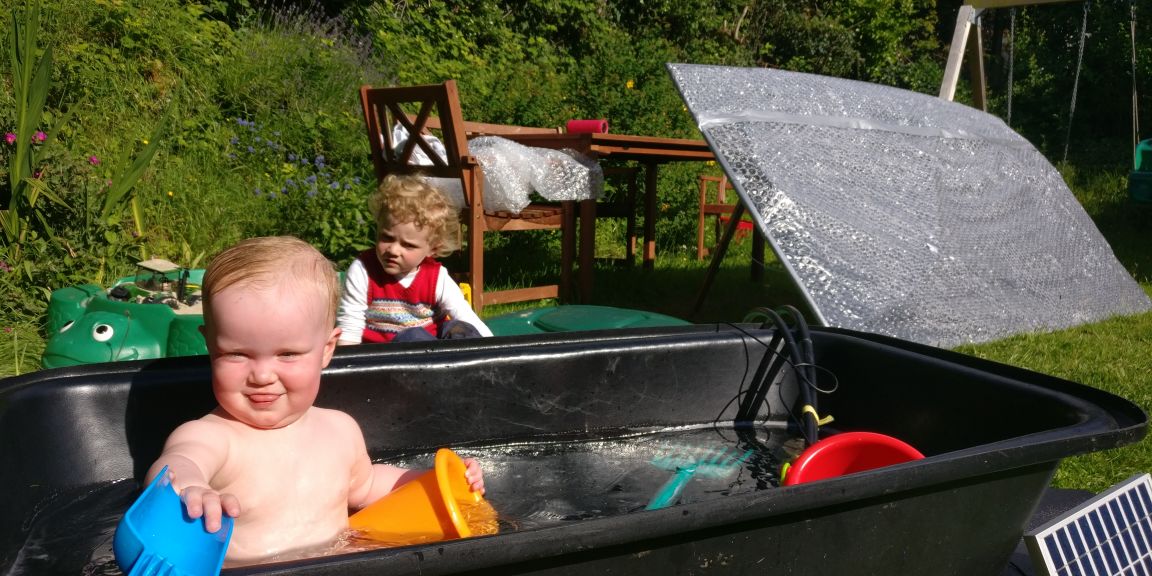 Little girl in a solar powered paddling pool