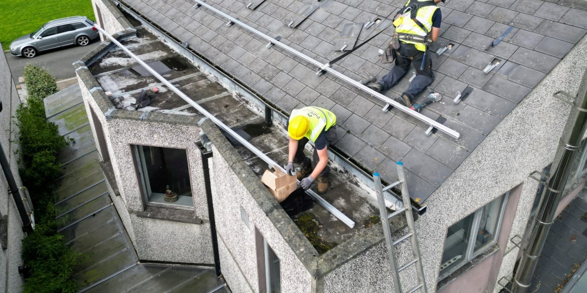 Solar panel installation team on a rooftop in Ireland